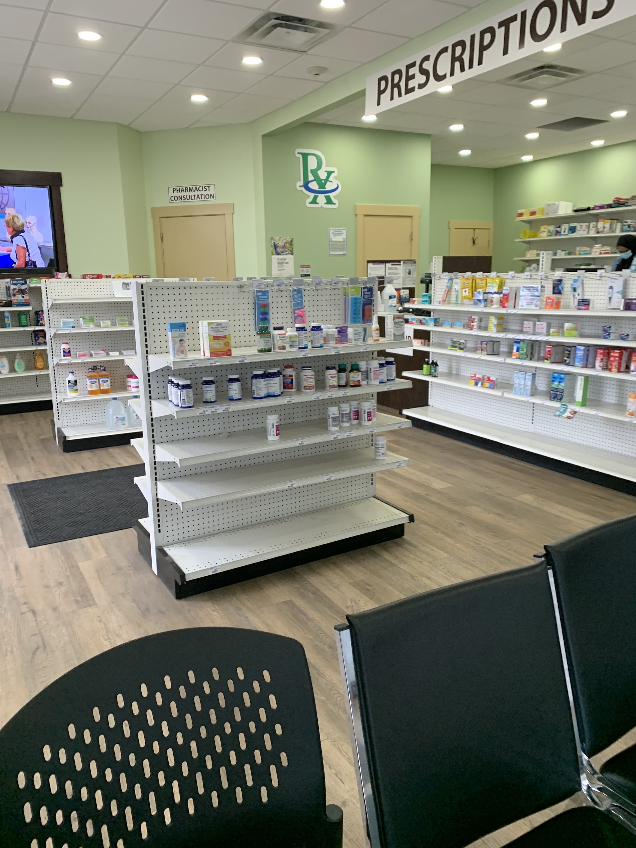 Clean, welcoming interior of Pharmacy 66 with green walls, organized shelving, and warm wood floors